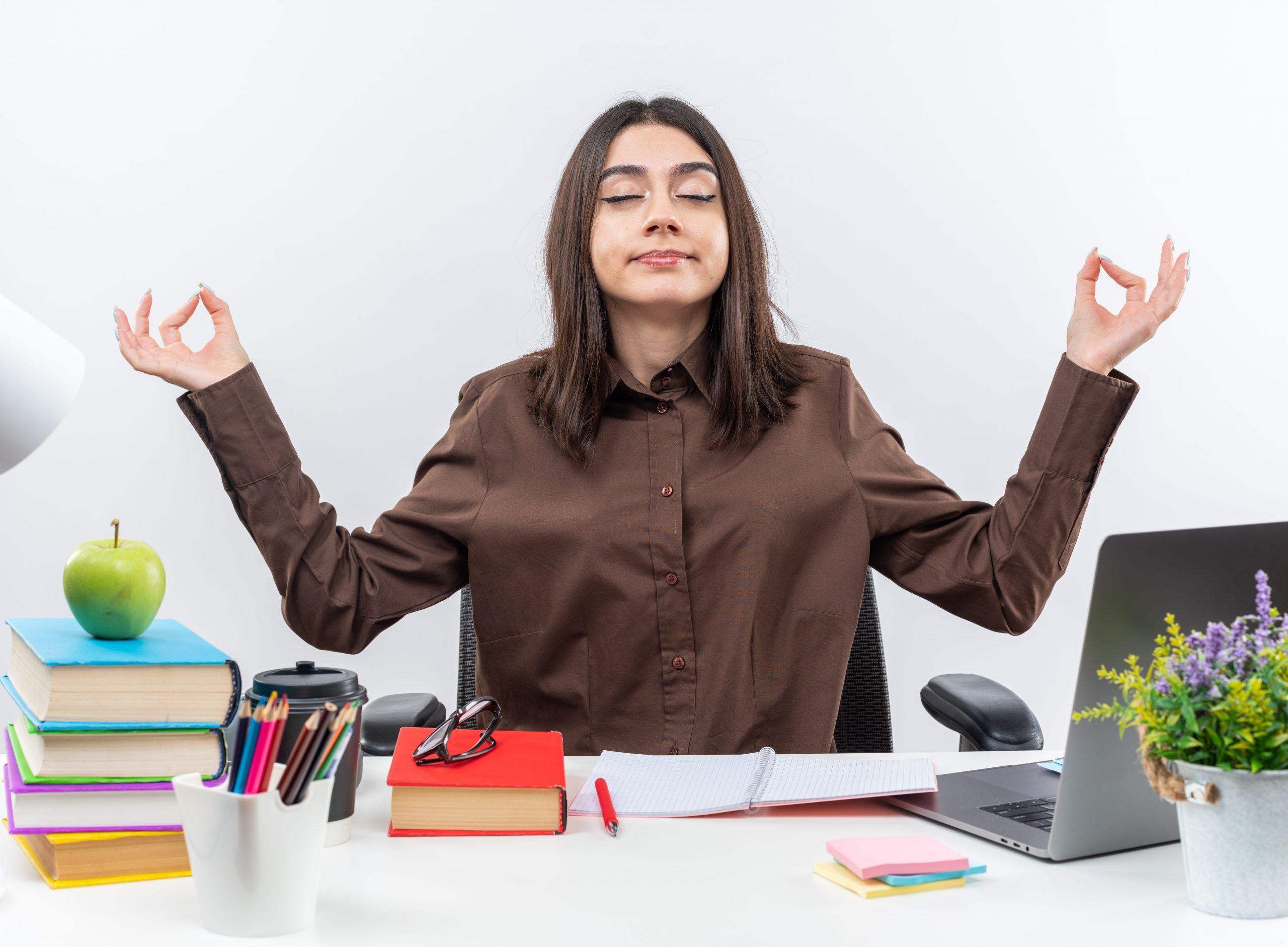 pleased-with-closed-eyes-young-school-woman-sits-table-with-school-tools-doing-meditation-gesture-min-scaled.jpg
